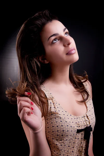 Unga och attraktiva kvinna som tittar upp tänkande, på svart, studio skott — Stockfoto