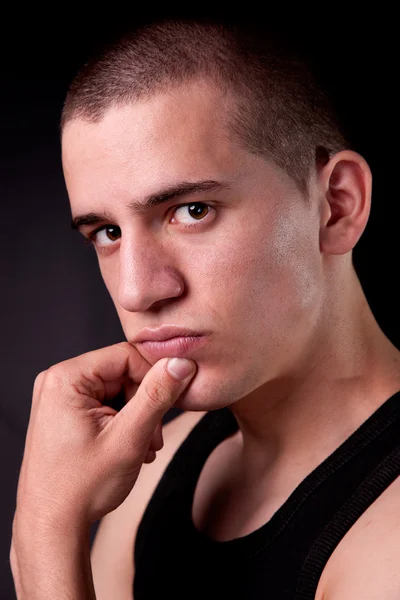 Portrait of a handsome man thinking, on black background. Studio shot — Stock Photo, Image