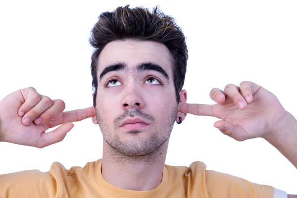 Joven, con los dedos en las orejas, aburrido, sin escuchar, en blanco, filmado en el estudio —  Fotos de Stock