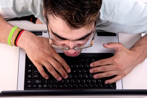 Young man surprised looking to computer. Studio shot. — Stock Photo, Image