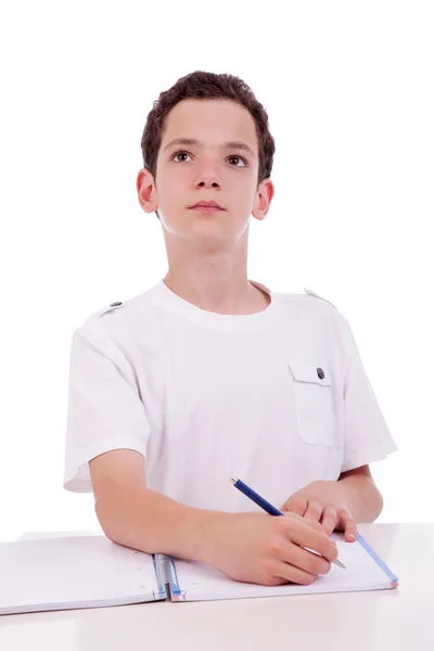 Söt pojke på skrivbordet studera och tänkande, isolerad på vit, studio skott — Stockfoto