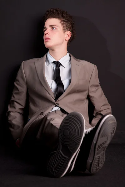 Giovane e affascinante uomo d'affari, sul pavimento dello studio girato — Foto Stock