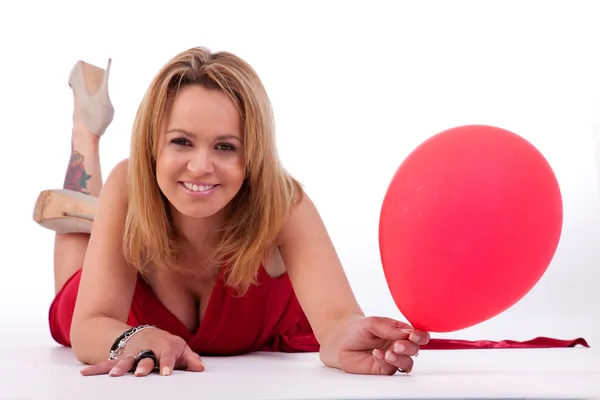 Mogen kvinna ljuger, hålla en ballon, isolerad på vit, studio skott — Stockfoto