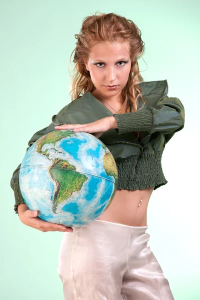 stock image Pretty blonde woman holding globe of world, studio shot