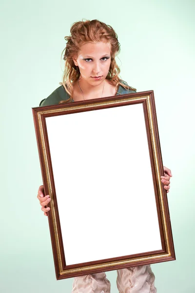 Beautiful woman holding a white decorative frame, studio shot — Stock Photo, Image
