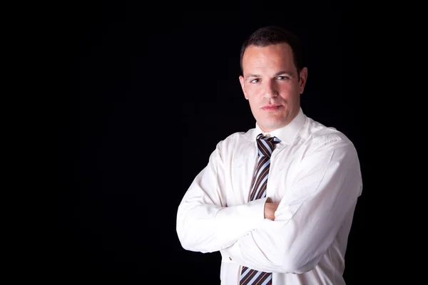 Portrait of a business man, arms crossed, isolated on black background. Studio shot. — Stock Photo, Image