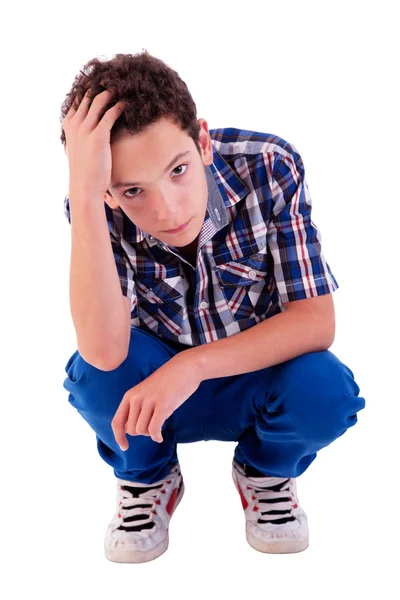 Young man squatting, worried, isolated on white background studio shot — Stock Photo, Image