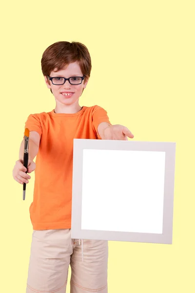 可爱的男孩和快乐与一支画笔和一张白纸，工作室拍摄 — 图库照片