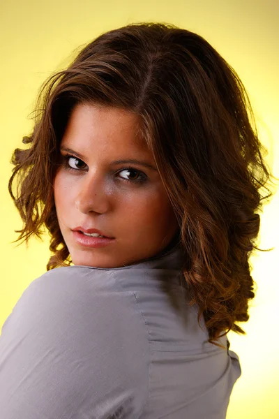 Mujer joven y atractiva mirando a la cámara, aislado en amarillo, toma de estudio — Foto de Stock