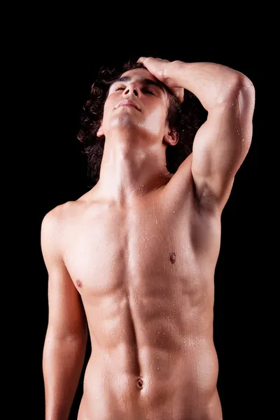 Torso of a sweat man in topless, isolated on black. Studio shot. 免版税图库图片
