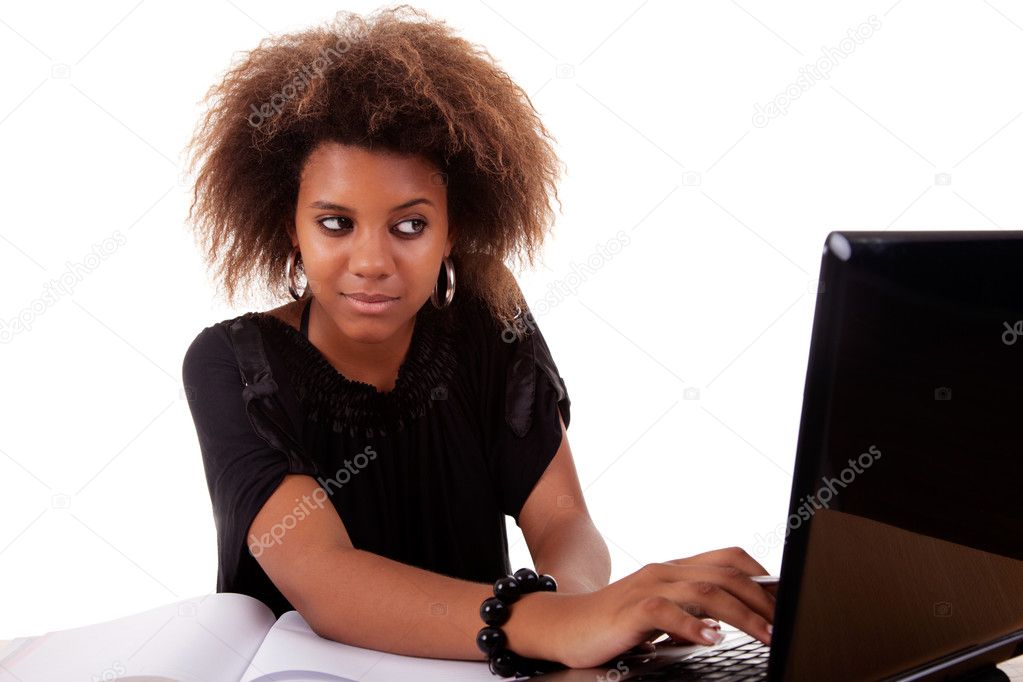 Young black women working on desk looking to computer, isolated on white background. Studio shot.