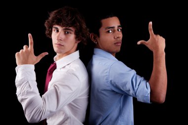 Two young man of different colors, back to back, with hand as an police officer with weapon raised, isolated on black, studio shot clipart