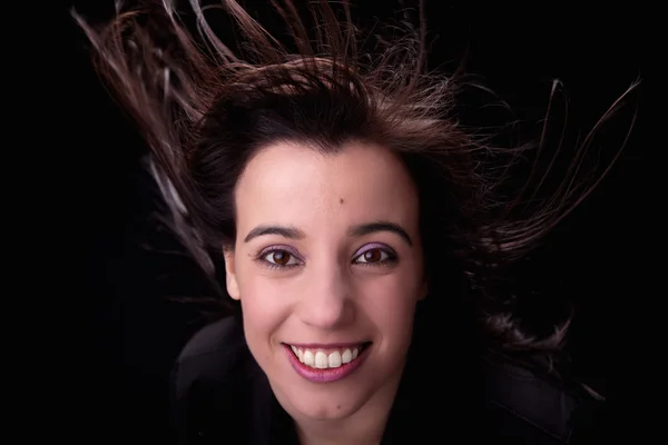 Молодая женщина спереди, с волосами на ветру — стоковое фото
