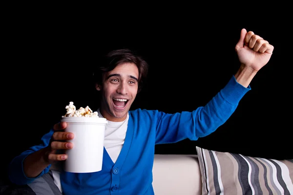 Happy young man, with popcorn watching — Stock Photo, Image