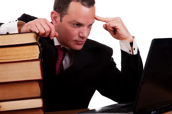 Hombre de negocios en el escritorio con libros, mirando a la computadora, aislado sobre fondo blanco, plano de estudio . — Foto de Stock