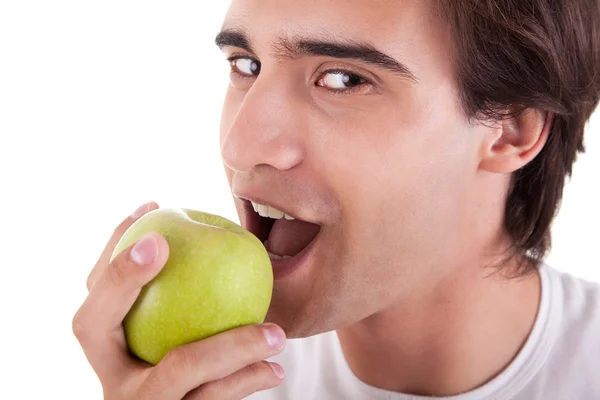 Mann isst einen grünen Apfel, isoliert auf weißem Hintergrund. Studioaufnahme. — Stockfoto