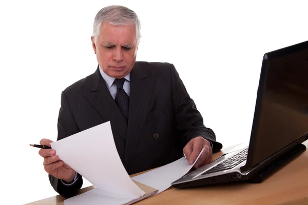 Reifer Geschäftsmann mit Blick auf den Computer, isoliert auf weißem Hintergrund. Studioaufnahme. — Stockfoto