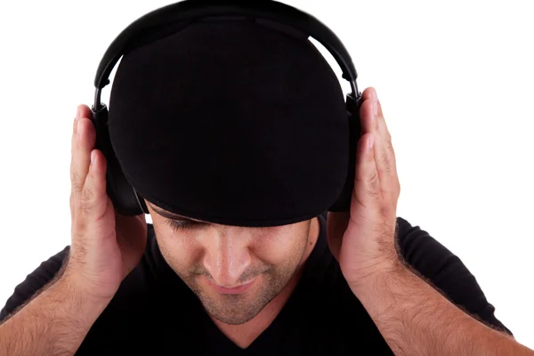 Hombre con sombrero escuchando música en auriculares, aislado sobre fondo blanco, toma de estudio — Foto de Stock