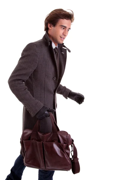 Portrait of a young man with a handbag, hasty, in autumn and winter clothes, isolated on white. Studio shot — Stock Photo, Image