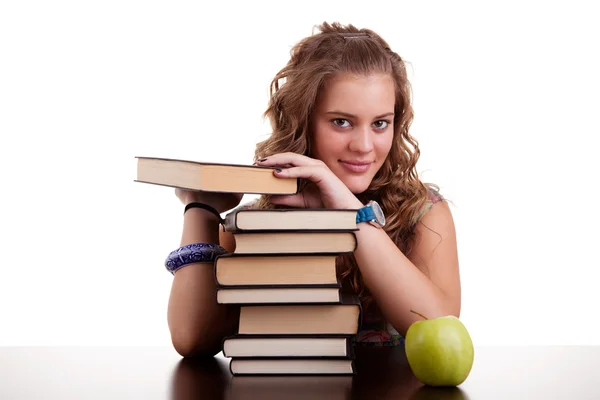 Щаслива красива дівчина, зі стопкою книг, і яблуком, ізольована на білому. Студійний знімок — стокове фото