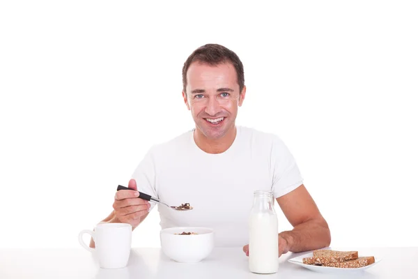 Красивий чоловік приймає сніданок, ізольований на білому, студійний знімок — стокове фото