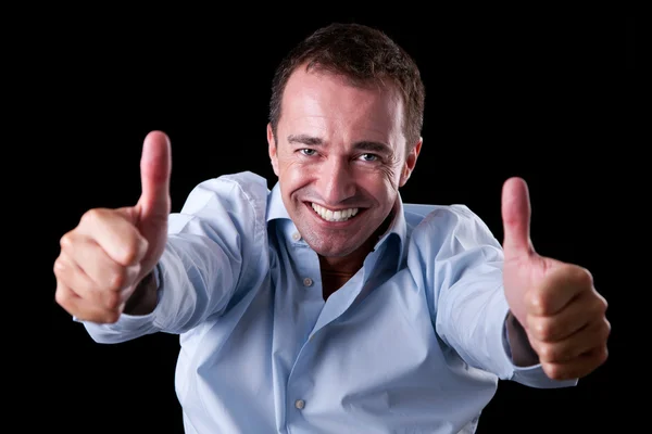 Молодий бізнесмен з великим пальцем, піднятим як знак успіху, ізольований на чорному тлі. студійний знімок — стокове фото
