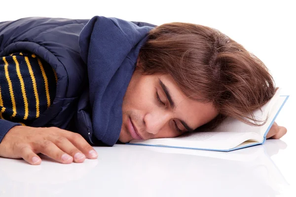 Giovane uomo sdraiato addormentato su un libro, isolato su bianco, ripresa in studio — Foto Stock