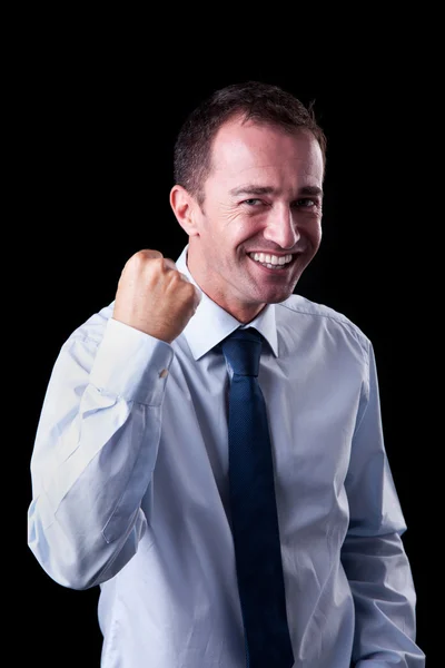 Портрет дуже щасливого бізнесмена з піднятою рукою, на чорному тлі. Студійний знімок — стокове фото