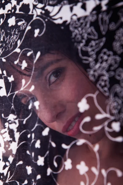 Vacker kvinna bakom en klarsynt gardin — Stockfoto