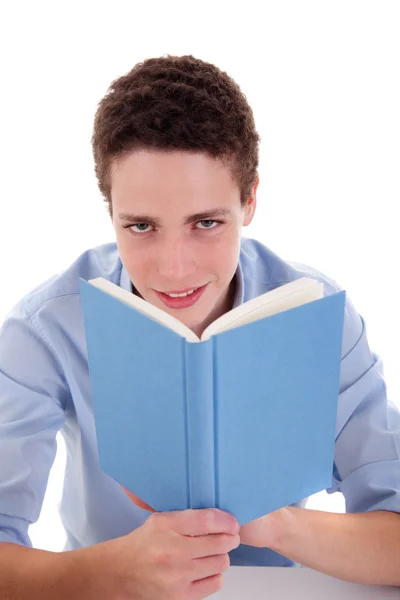 Netter Junge liest ein Buch auf seinem Schreibtisch, isoliert auf Weiß, Studioaufnahme — Stockfoto