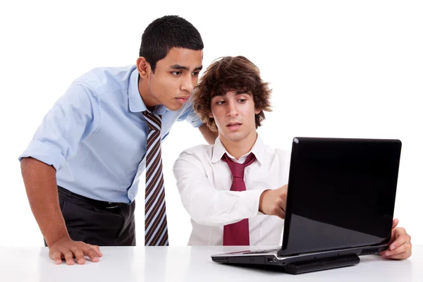 Dois jovens homens de negócios trabalhando juntos em um laptop, isolados em branco, tiro estúdio — Fotografia de Stock