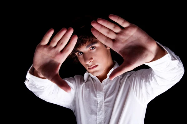 Netter Junge mit erhobenen Händen, isoliert auf schwarzem Hintergrund, Studioaufnahme — Stockfoto