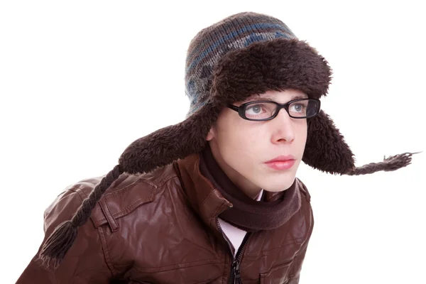 Νεαρό αγόρι ψάχνει σοβαρά, με χειμωνιάτικα ρούχα και καπέλο στον άνεμο, απομονωμένα σε λευκό, studio που γυρίστηκε — Φωτογραφία Αρχείου