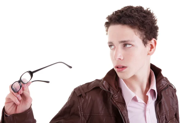 Ung pojke tittar allvarligt, med glasögon i hand, isolerad på vit, studio skott — Stockfoto