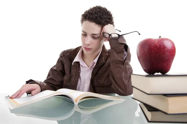 Cute boy studying and thinking, along with one on apple top of some books — Stock Photo, Image