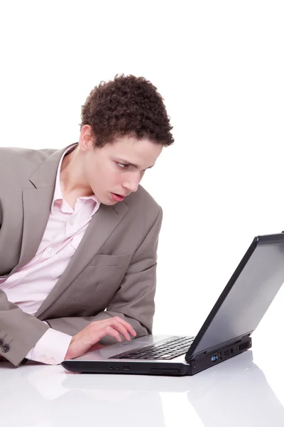 打字和看屏幕的笔记本电脑，白色，工作室射击上孤立的年轻人 — 图库照片