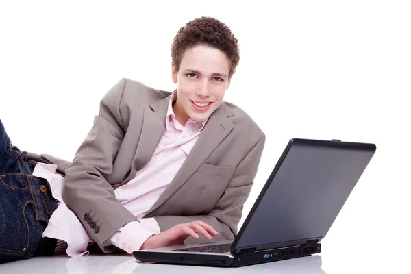 Jovem sorrindo e digitando no laptop, isolado em branco, tiro estúdio — Fotografia de Stock