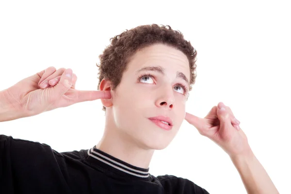Молодий чоловік, тримаючи пальці в вухах, нудно, не слухаючи, на білому, студійний знімок — стокове фото