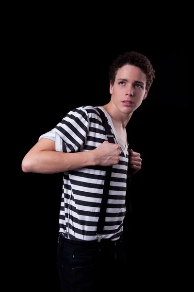 Молодий впевнений чоловік тримає брекети для штанів, ізольований на чорному, студійний знімок — стокове фото