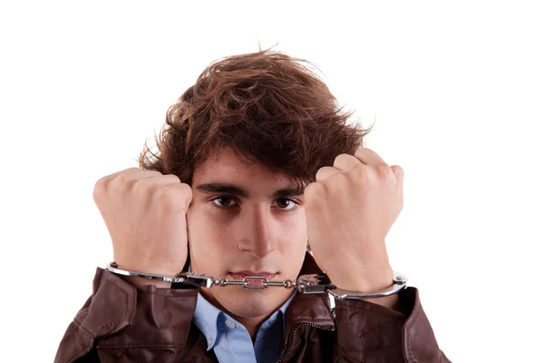 Руки на лице молодого человека, с наручниками на руках, изолированные на белом фоне — стоковое фото