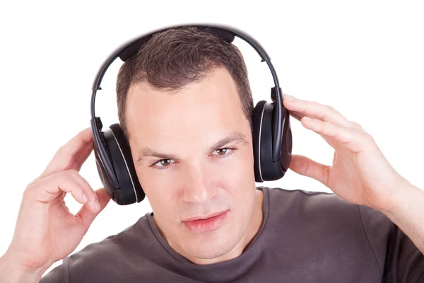 Чоловік слухає музику в навушниках, ізольований на білому тлі, студійний знімок — стокове фото