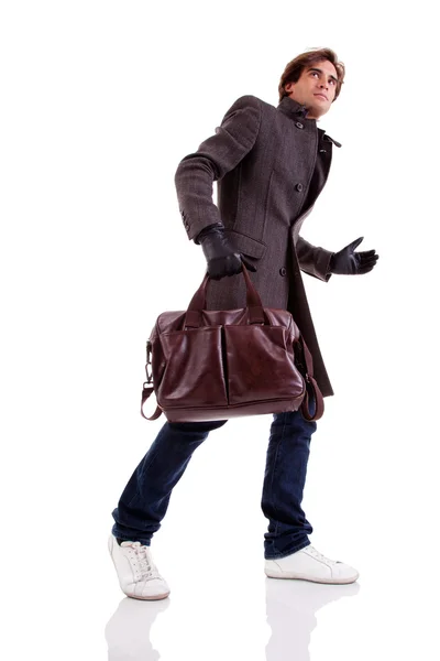 Retrato de un joven con un bolso, apresurado, en ropa de otoño e invierno, aislado en blanco. Captura de estudio — Foto de Stock