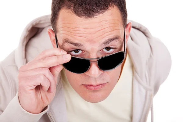 Portret van een jonge volwassen man kijken over zijn zonnebril Rechtenvrije Stockfoto's