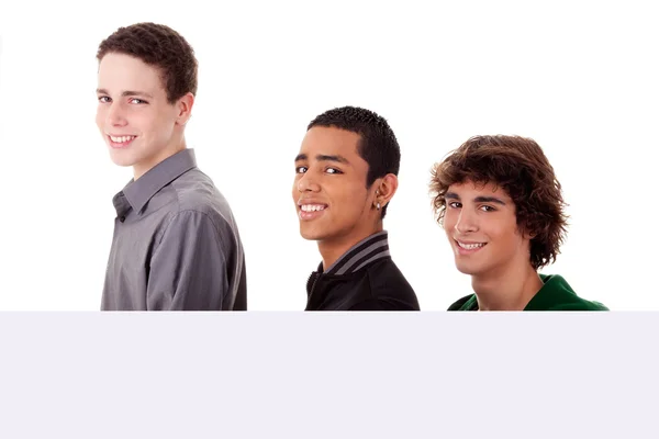 Drei junge, verschiedenfarbige Männer, die ein weißes Brett in der Hand halten und in die Kamera schauen, isoliert auf weißem Hintergrund Stockbild