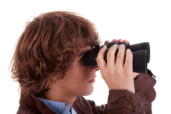 Young boy looking through binoculars, isolated on white, studio shot Royalty Free Stock Images