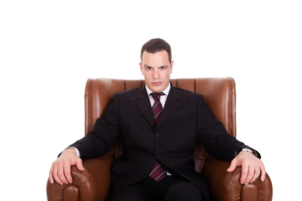 Geschäftsmann auf einem Stuhl sitzend, isoliert auf weißem Hintergrund. Studioaufnahme. lizenzfreie Stockfotos