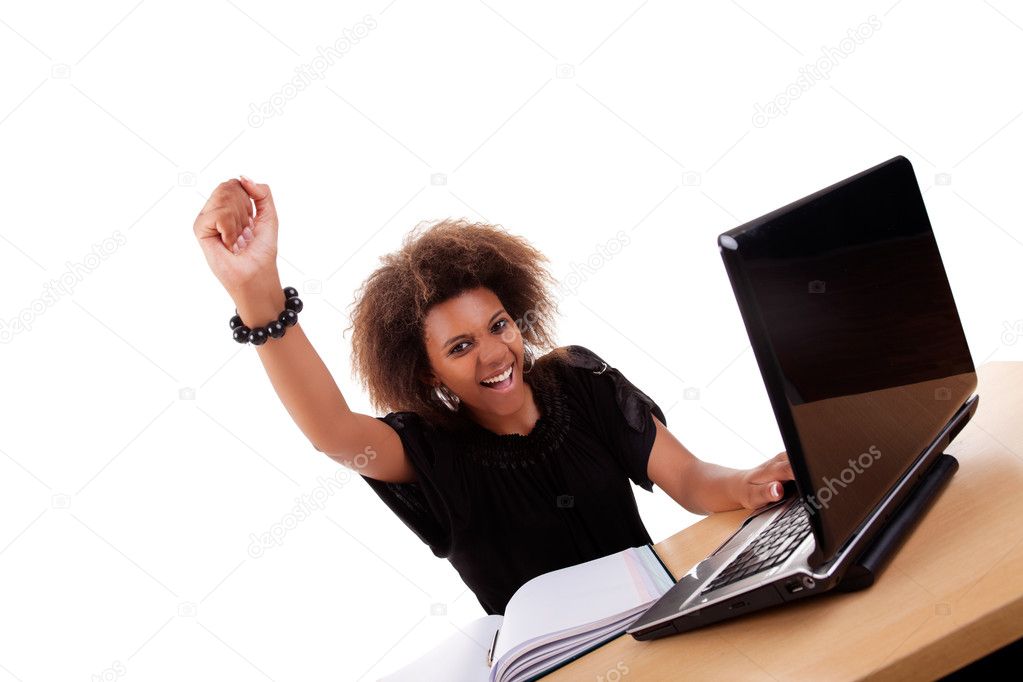 Young black women in front of the computer, arm raised and happy, isolated on white background. Studio shot.