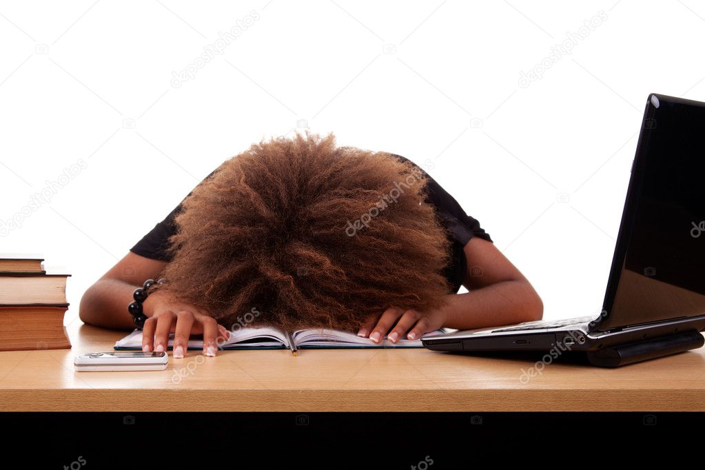 Stressed young black woman, sitting at a table among books and laptop on a white background.