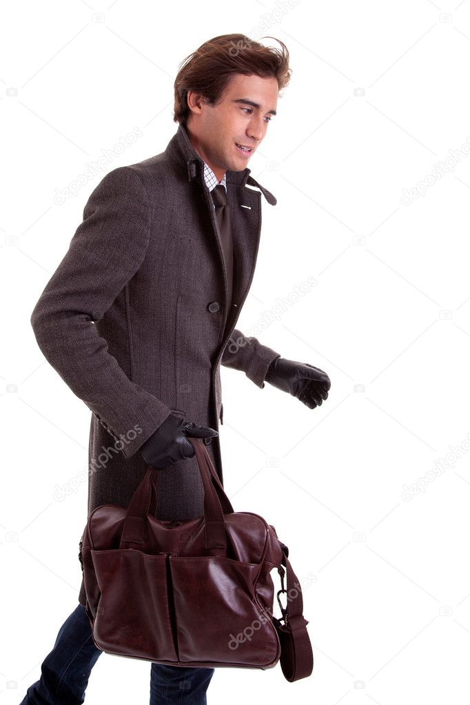 Portrait of a young man with a handbag, hasty, in autumn and winter clothes, isolated on white. Studio shot