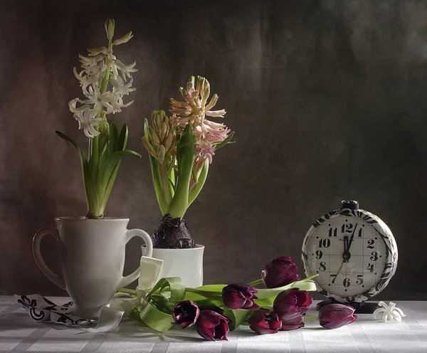 Stilleven met Lentebloemen en een klok — Stockfoto